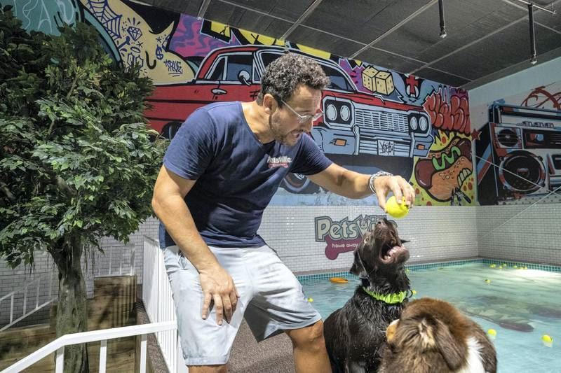 A Petsville staff member plays with some of the dogs at the waterpark. 