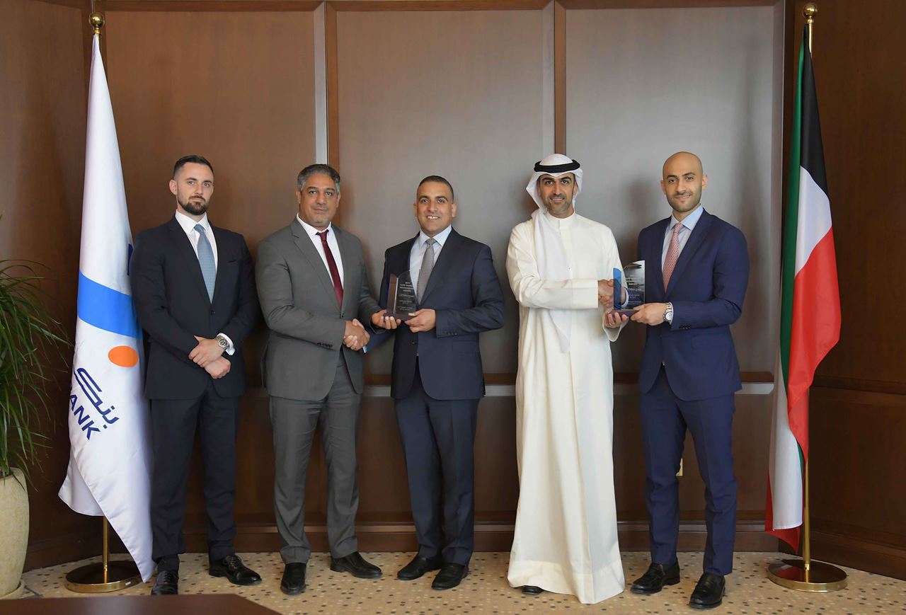 Mr. Mohammad Najeeb Al-Zanki, Head of Corporate Banking - Assistant General Manager, and Mr. Mohammad Al Zayed, Head of Operations at Burgan Bank receiving the award from J.P. Morgan’s representatives