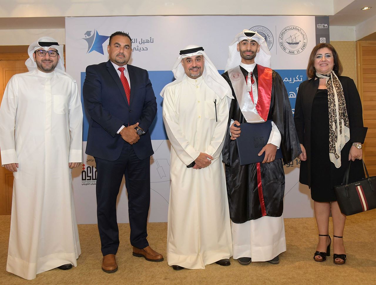  Mr. Raed Abdullah Al-Haqhaq with the Burgan Bank team and one of the graduates